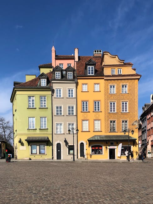 Charming colorful buildings line a cobblestone street in Warsaw's Old Town.