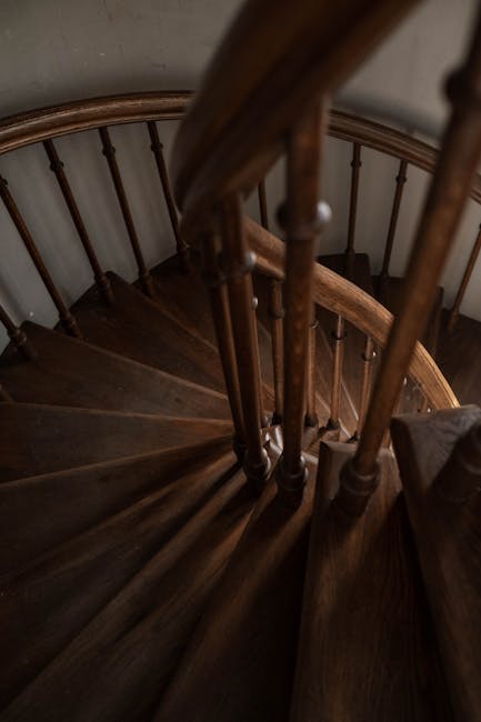 A classic wooden spiral staircase showcases intricate craftsmanship indoors.